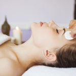 Relaxed woman with a deep cleansing nourishing face mask applied to her face. Spa treatment